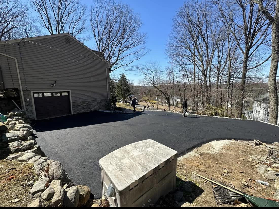Asphalt driveway leading to a hillside garage
